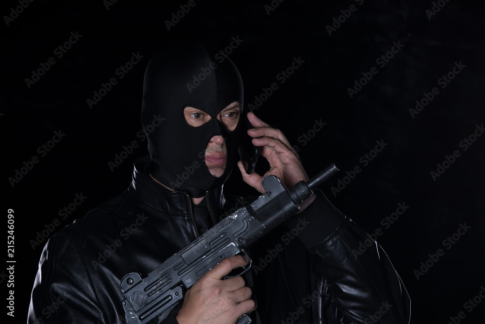 a man in a mask and with a gun and with a phone a man in a mask and with a gun and with a phone