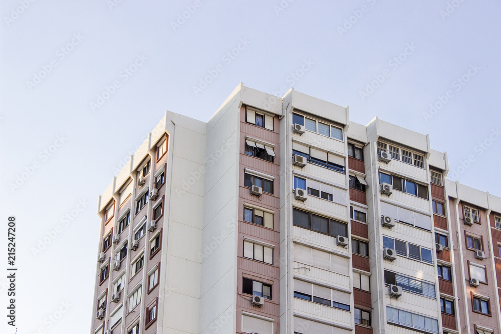 Horizontal detail shot of tall concrete mass housing building corner in Izmir at Turkey with blue sky background