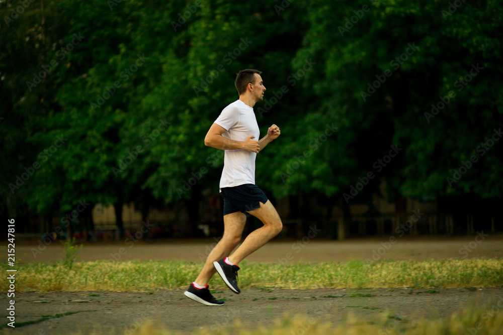 Athletic young man running in nature. Healthy lifestyle Athletic young man running in nature. Healthy lifestyle