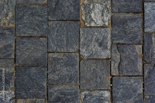 Dark pavement with cobblestone square blocks of natural stone