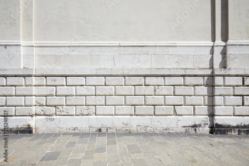Foto Empty tiled stone sidewalk and ancient white wall with molding