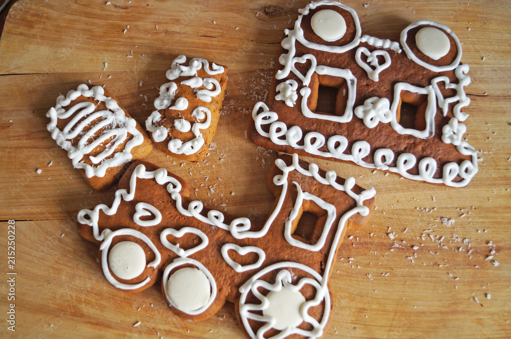 Christmas gingerbread decorated with white icing lie on a wooden table