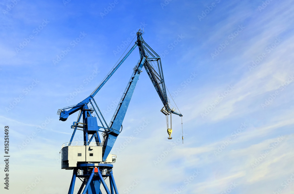 Port crane against a blue sky with a light cloud cover Port crane against a blue sky with a light cloud cover