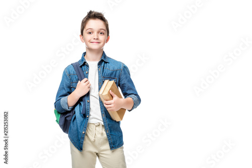 schoolboy holding backpack and books isolated on white photo