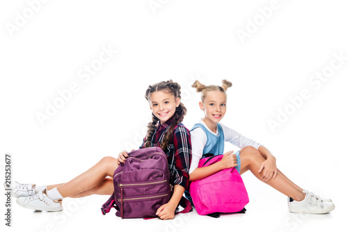 Wallpaper Mural schoolchildren sitting with backpacks and looking at camera isolated on white Torontodigital.ca