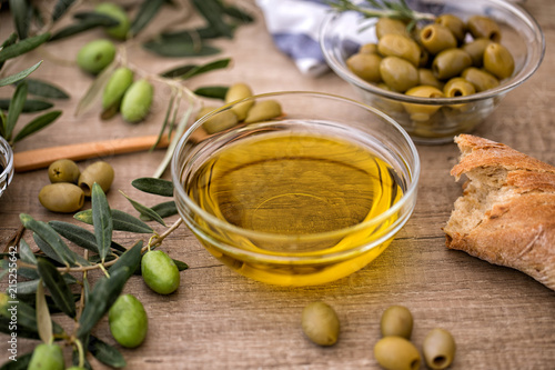 Greek extra virgin healthy Olive oil with olive on wooden background.
