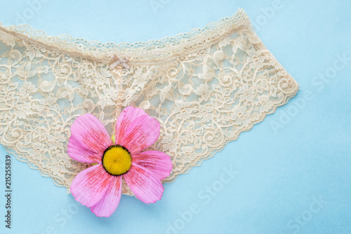Fotografie beige lace briefs on a blue background. concept of virginity