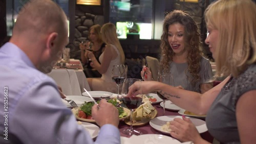 Company of adult people have a dinner at restaurant