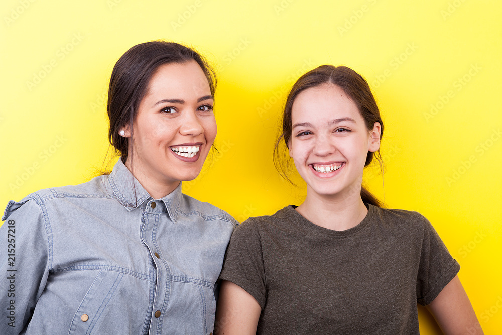 Best girlfriends in studio photo on yellow background Best girlfriends in studio photo on yellow background