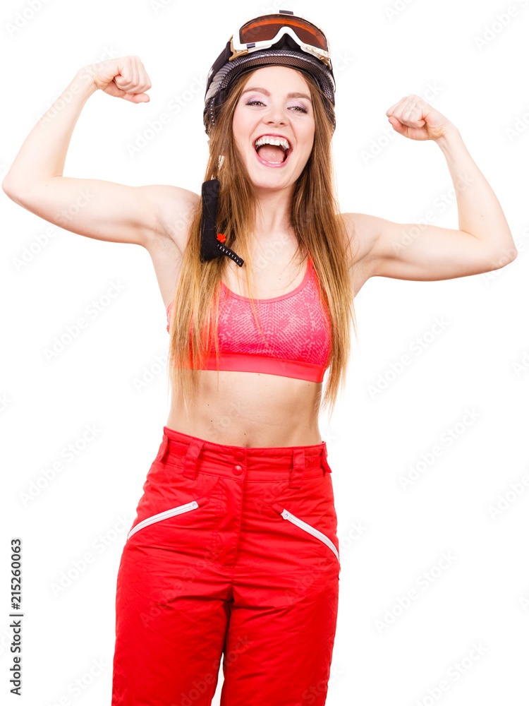 Woman wearing ski suit, helmet with goggles showing muscles Woman wearing ski suit, helmet with goggles showing muscles