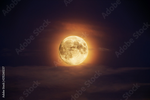Bright full moon against dark clouds vibrant colors