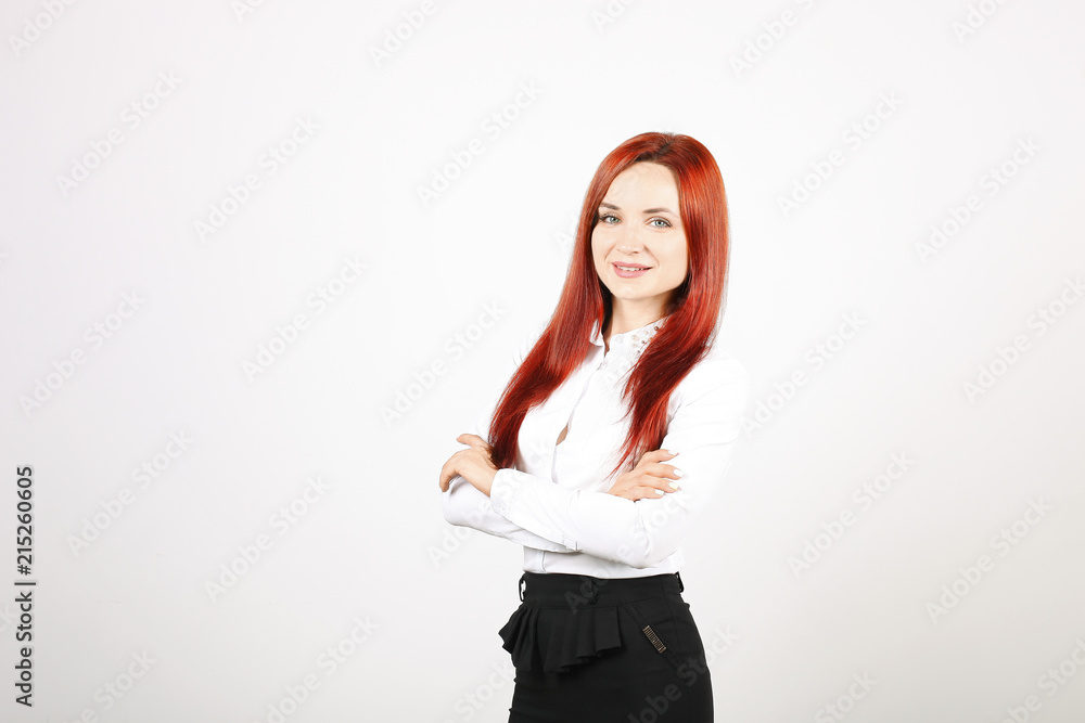 Beautiful businesswoman wearing formal wear, black skirt & white blouse standing with arms folded on chest. Attractive woman with red hair and make up, hands crossed. Copy space background, close up.