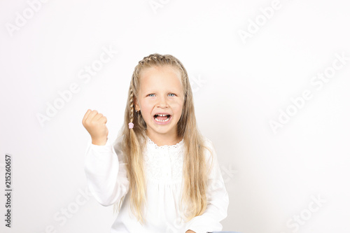 Portrait of beautiful, funny and angry four year old little girl raging with fists, showing knuckles, frowning. Female child screaming, behaving capriciously, crying. Background, copy space, close up.