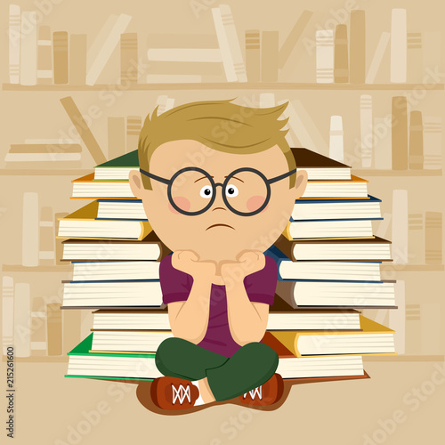 Unhappy nerd boy sitting in front of stack of books and bookshelf in school library