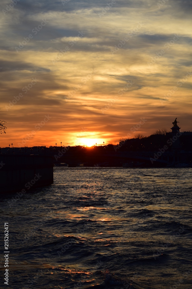 Sunset on the Seine River in Paris with the Pont Alexandre III in silhouette Sunset on the Seine River in Paris with the Pont Alexandre III in silhouette