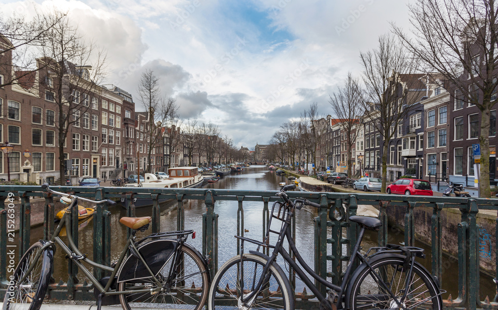 Canals of Amsterdam area and waterfront in Holland, The Netherlands. Cloudy day during winter season in Amsterdam, The Netherlands. This modern city attract every year thousands of tourists.
