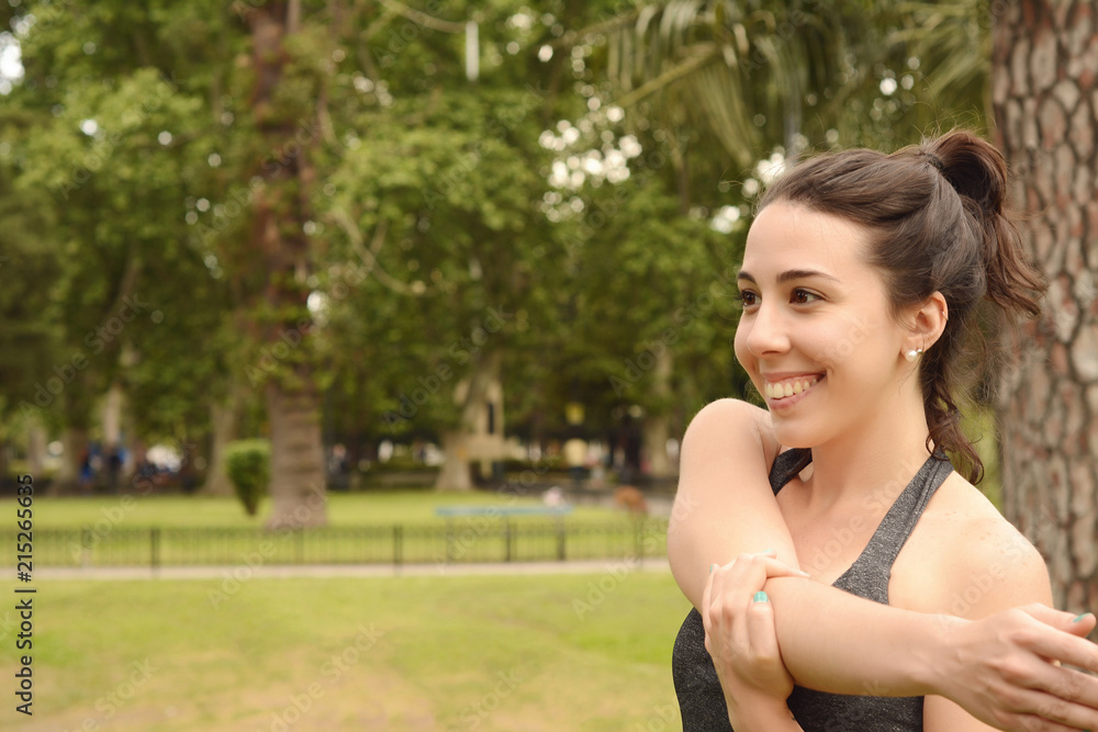 Portrair of young beautiful woman doing exercise at park