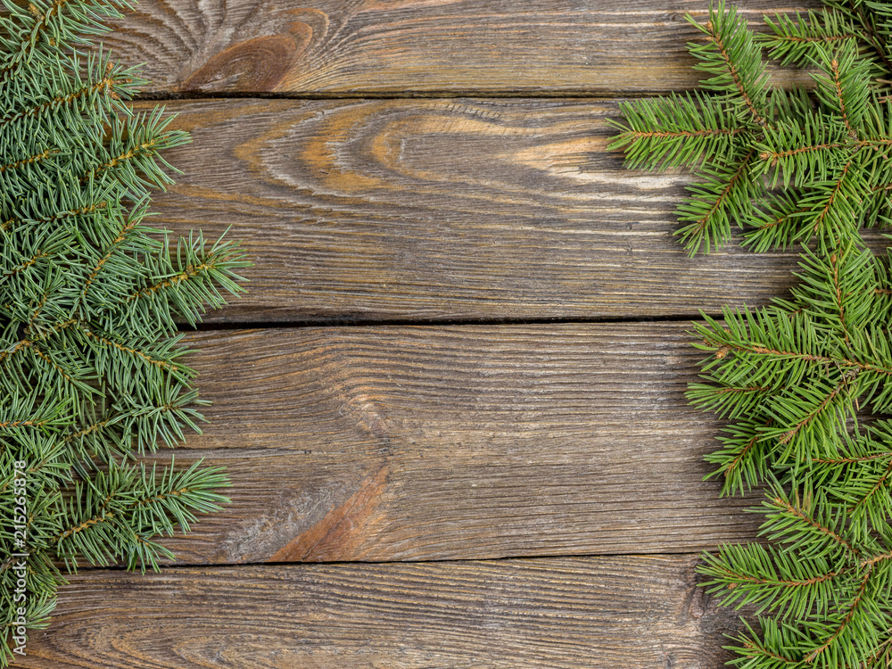 Christmas close-up of Christmas tree branches on vintage wooden background. Top view of a Christmas workplace. New Year frame or Xmas Mockup. Christmas close-up of Christmas tree branches on vintage wooden background. Top view of a Christmas workplace. New Year frame or Xmas Mockup.