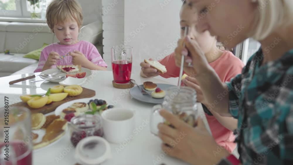 Happy young family having breakfast in the kitchen. Nutritive meal. Happy young family having breakfast in the kitchen. Nutritive meal.