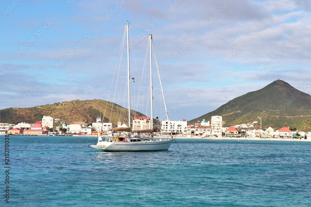 Sailboat on the ocean with a tropical island in the background Sailboat on the ocean with a tropical island in the background