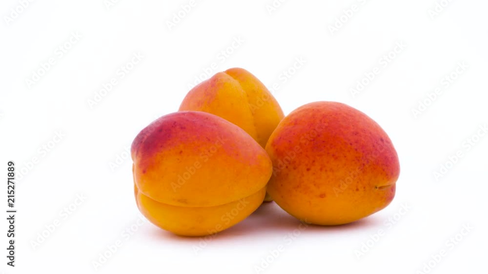 Three apricot fruits rotating on the on the turntable isolated on the white background. Close up. Macro. Three apricot fruits rotating on the on the turntable isolated on the white background. Close up. Macro.
