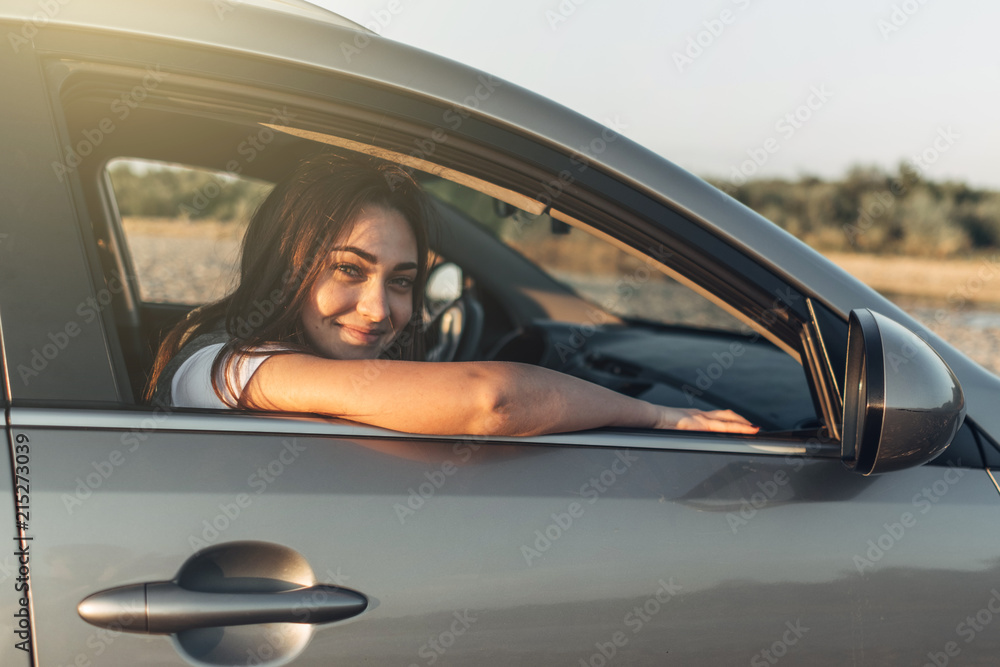 Happy Woman on Roadtrip into the Sunset in SUV Car