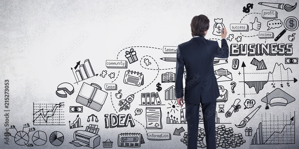 Back view of a businessman drawing a business sketch on a gray wall Back view of a businessman drawing a business sketch on a gray wall
