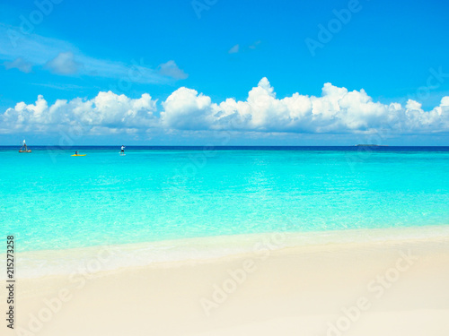White sand beach turquoise water sea and blue sky in Maldives island for summer vacations holiday concept.