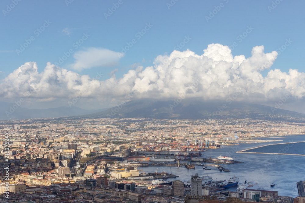 Naples and port of Mediterranean sea and volcano Vesuvius top view. Naples cityscape. Volcano Vesuvius in clouds. Volcano and sea landscape. Travel concept. Aerial italian landscape. Neapol panorama. 