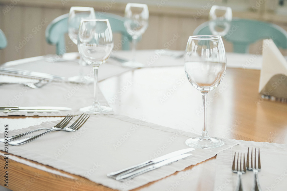 Wine glasses on table. Many glasses ready to serve drinks at a party. Family dinner. Fork and knife. Wine glasses on table. Many glasses ready to serve drinks at a party. Family dinner. Fork and knife.