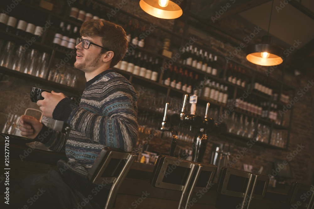Man having coffee while sitting at the bar counter Man having coffee while sitting at the bar counter