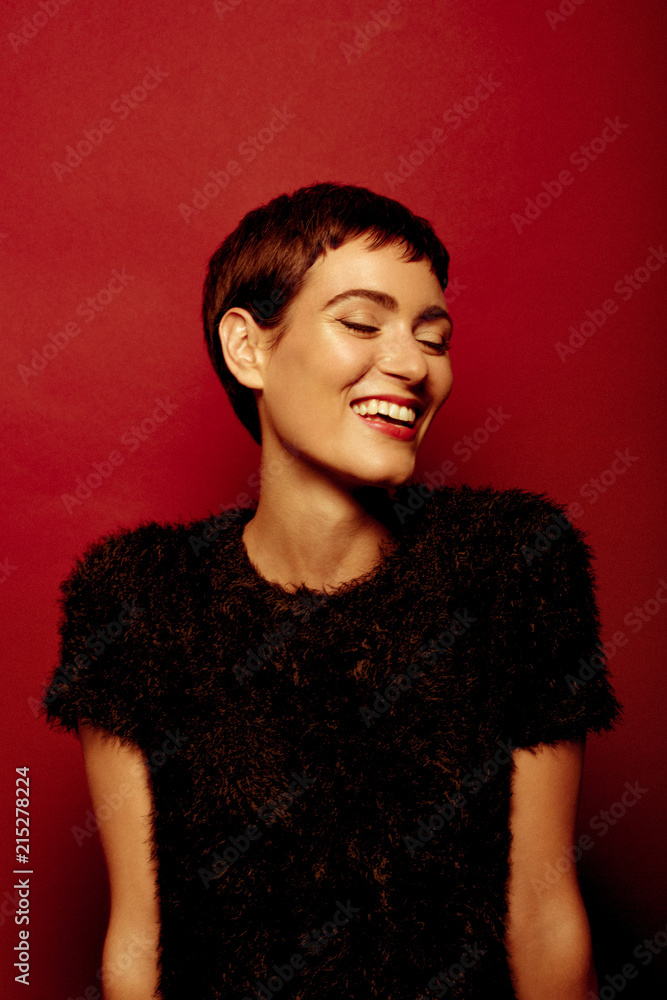 Beautiful and confident short haired woman portraits in her 30s shot in studio isolated over red background Beautiful and confident short haired woman portraits in her 30s shot in studio isolated over red background