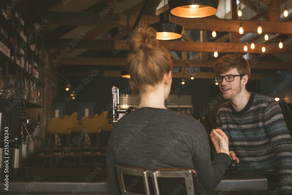 Couple talking to each other at bar counter Couple talking to each other at bar counter
