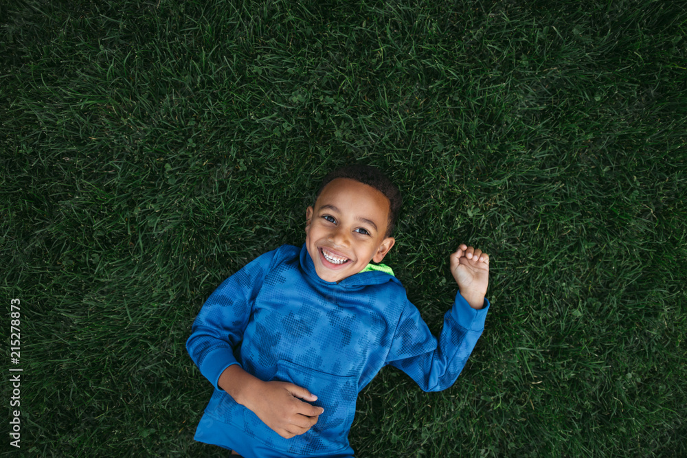 Little boy having fun outside rolling and lying on grassy field Little boy having fun outside rolling and lying on grassy field