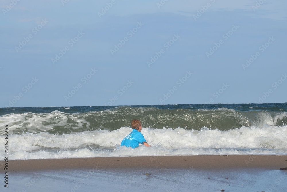 Kind - Junge badet im Meer bei hohen Wellen - Wellengang - Ostsee Kind - Junge badet im Meer bei hohen Wellen - Wellengang - Ostsee