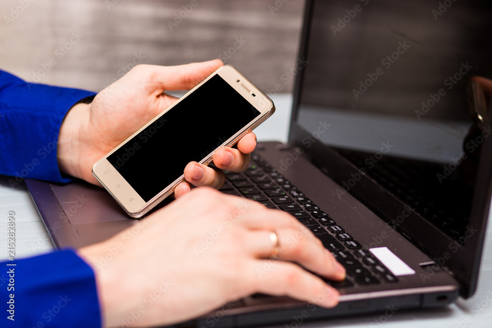 Businessman using laptop with telephone at office. Close-up image