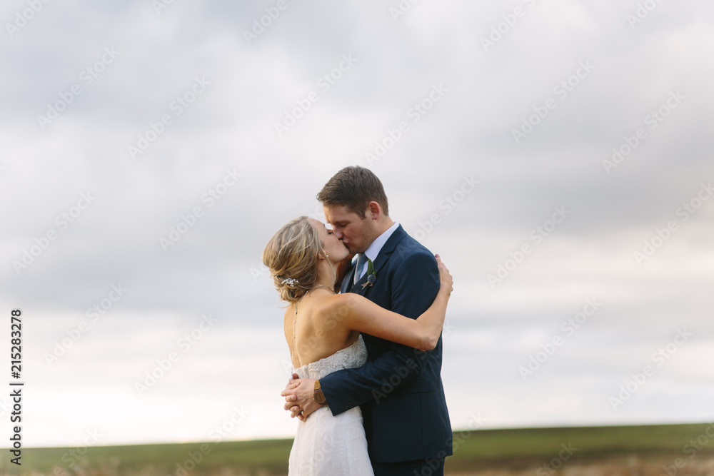 Wedding Couple Embracing under Dramatic Sky Wedding Couple Embracing under Dramatic Sky