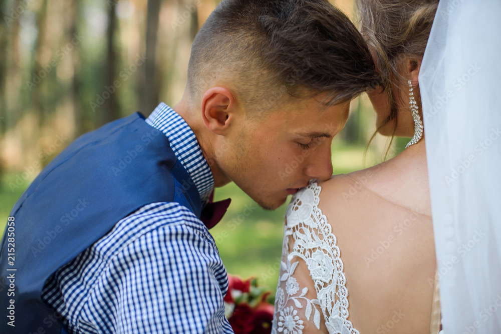 Bride and groom in a park kissing.couple newlyweds bride and groom at a wedding in nature green forest are kissing photo portrait.Wedding Couple Bride and groom in a park kissing.couple newlyweds bride and groom at a wedding in nature green forest are kissing photo portrait.Wedding Couple