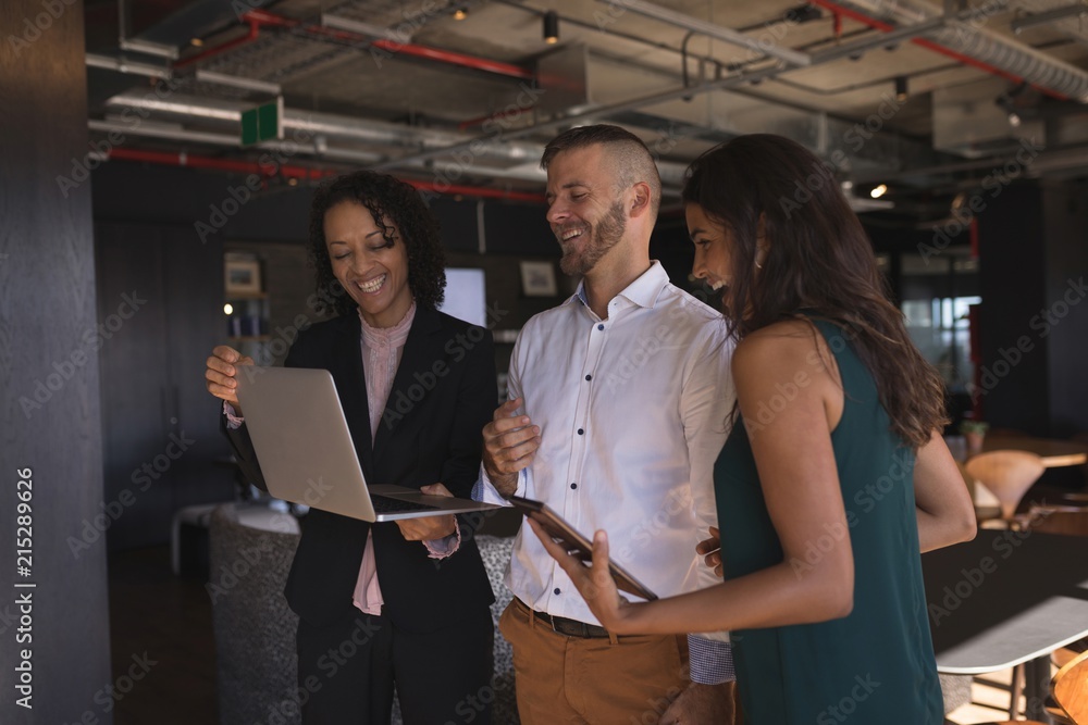 Business executives discussing over laptop Business executives discussing over laptop