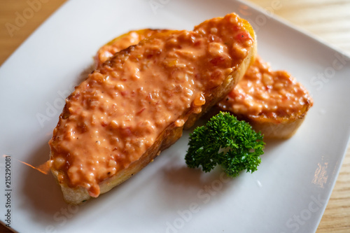 Rouille, a sauce that consists of olive oil with breadcrumbs, garlic, saffron and cayenne pepper on a baguette. Served as a garnish with bouillabaisse, traditional fish stew. Provencal delicacy.