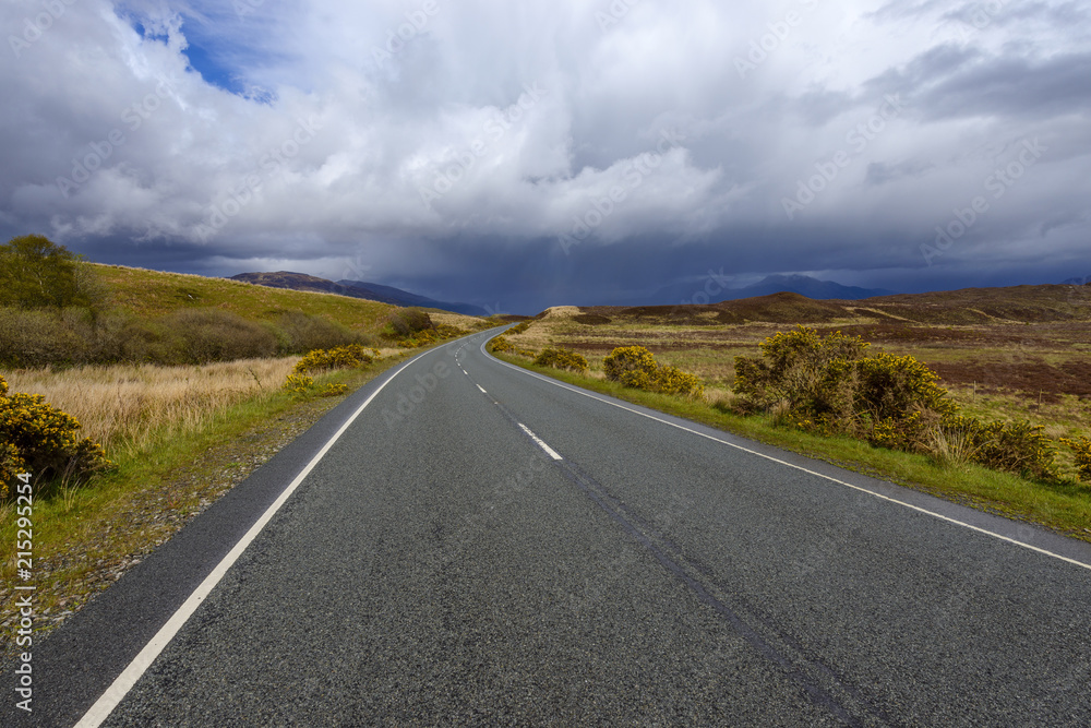 Country road with dramatic clouds in springtime on the Isle of Skye in Scotland, United Kingdom Country road with dramatic clouds in springtime on the Isle of Skye in Scotland, United Kingdom
