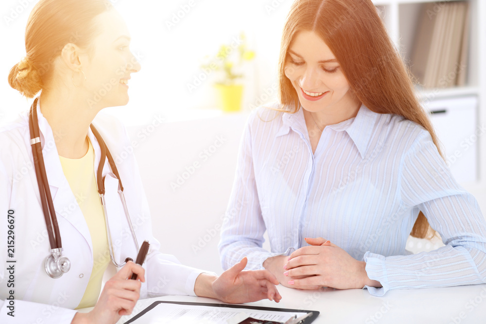 Doctor and patient sitting at the desk near window Doctor and patient sitting at the desk near window