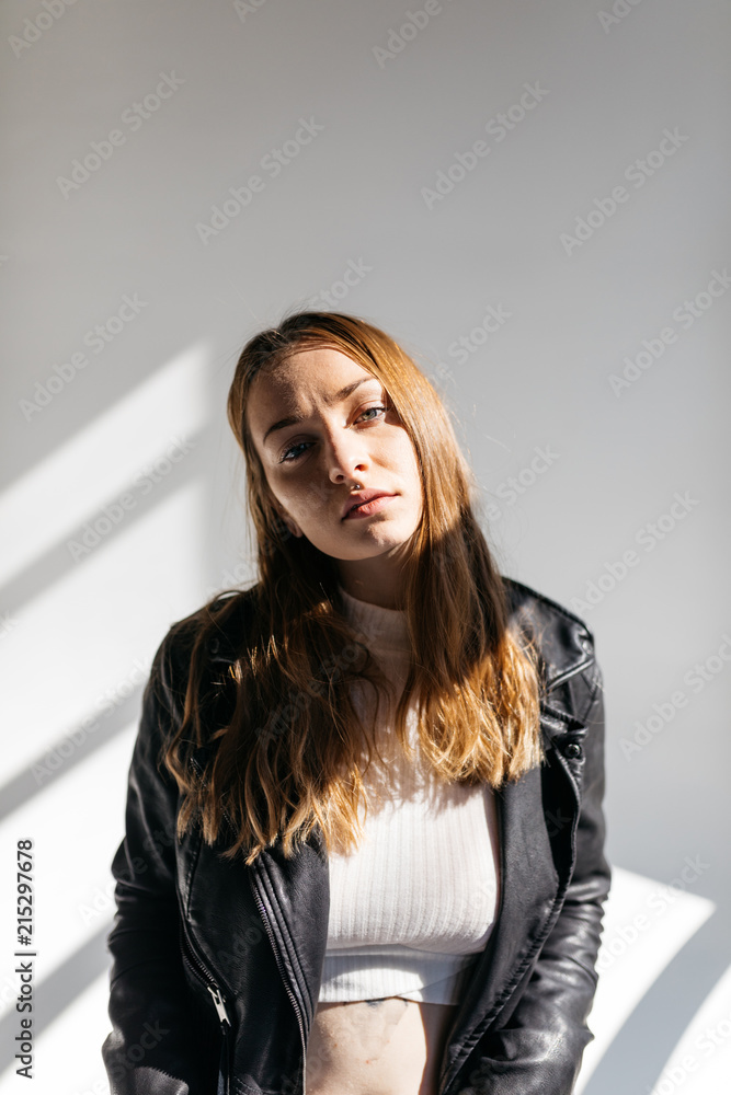 Portrait of Young woman in studio wearing leather jacket with fringe on white background. Portrait of Young woman in studio wearing leather jacket with fringe on white background.