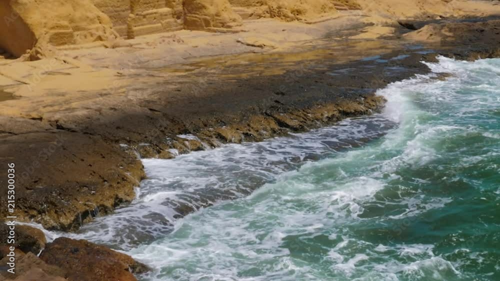Green sea waves with white foam near rocky coast, slow motion Green sea waves with white foam near rocky coast, slow motion