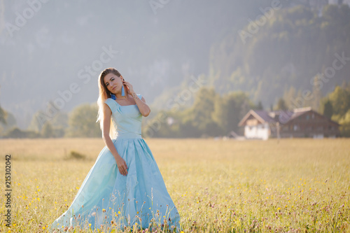 blond girl in blue dress infront of the castle © Tetiana