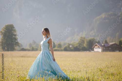 blond girl in blue dress infront of the castle © Tetiana