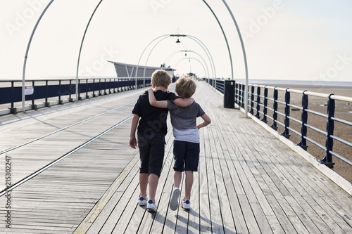 Two children walking on the Pier together photo