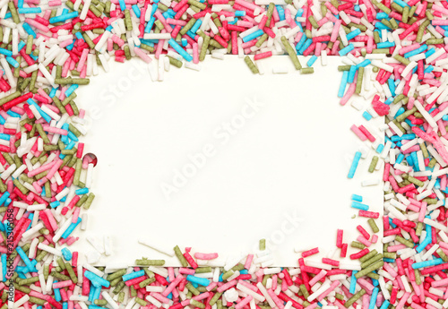 White paper with colorful sprinkles around, party design element. Festive holiday background with copy space. Celebration concept.