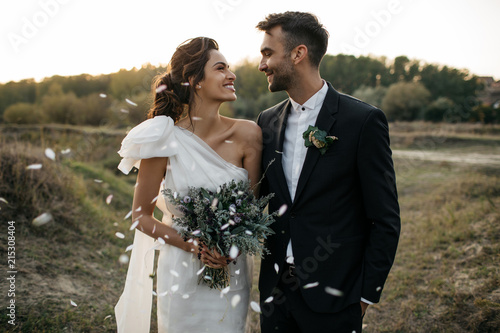 Bride and groom in field at sunset photo