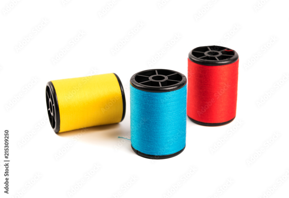 Blue red yellow thread reels isolated on white background. Blue red yellow thread reels isolated on white background.